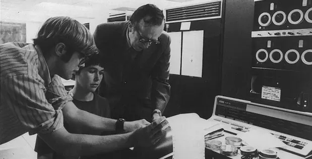 J.C.R. Licklider discusses concepts with students at the Information Processing Techniques Office. Image from DARPA.